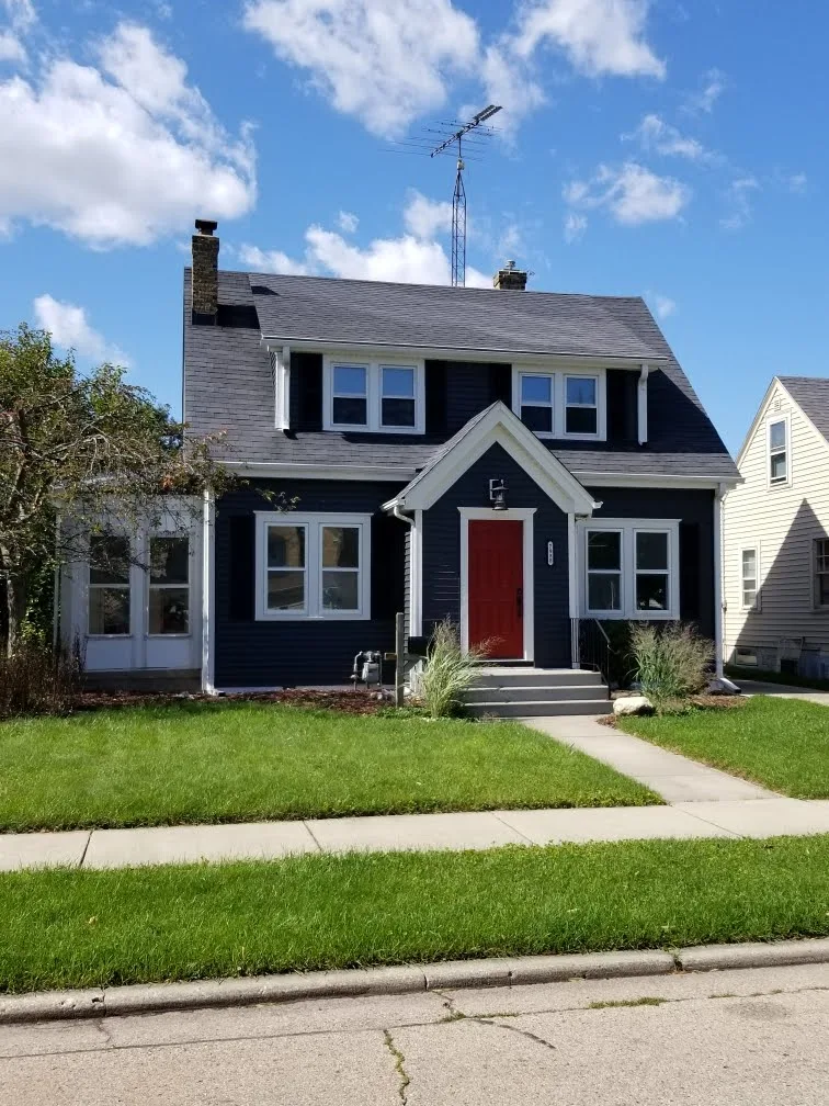 new roof on dark blue house with red front door.